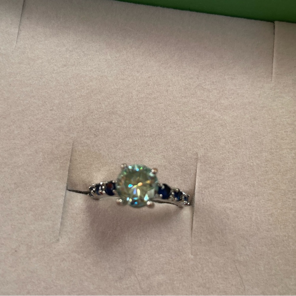 2.20 carat Round Blue Moissanite center surrounded by Blue Sapphires.. size 6.